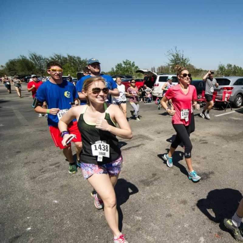 a group of people running in a parking lot.